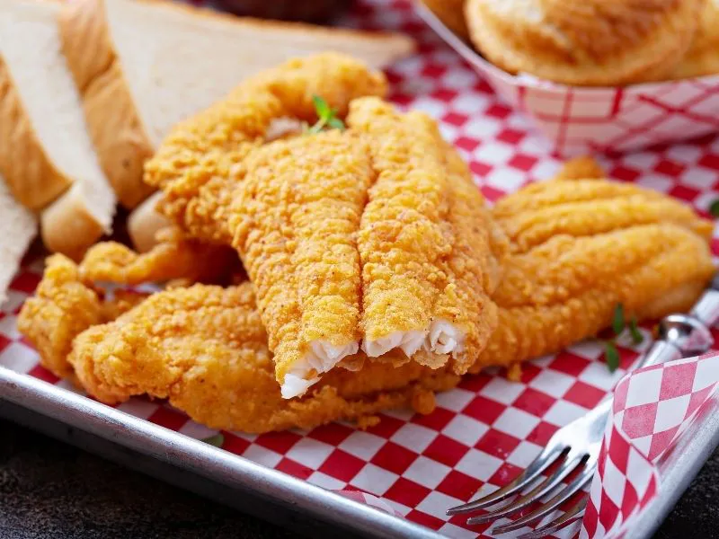 Crispy fried chicken strips served with toast on checkered paper at Which Wings, Fast Food Restaurant in Fort Worth